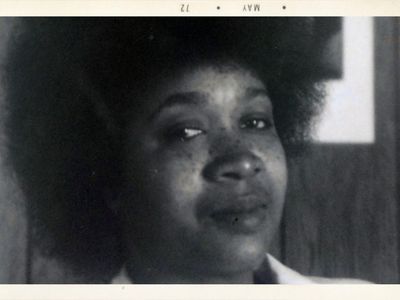 Black woman with an Afro. Black-and-white photo dated May 72 in the top border.