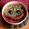 A soup bowl monster made of yarn, created by DALL-E 2.